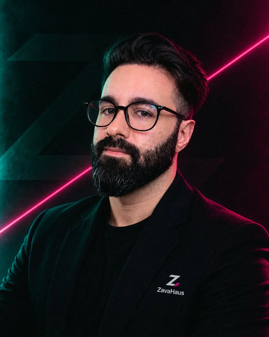 Retrato de Vitor Zavarize: fundo escuro com o símbolo da ZavaHaus em relevo e uma linha de luz magenta cortando a cena na diagonal.